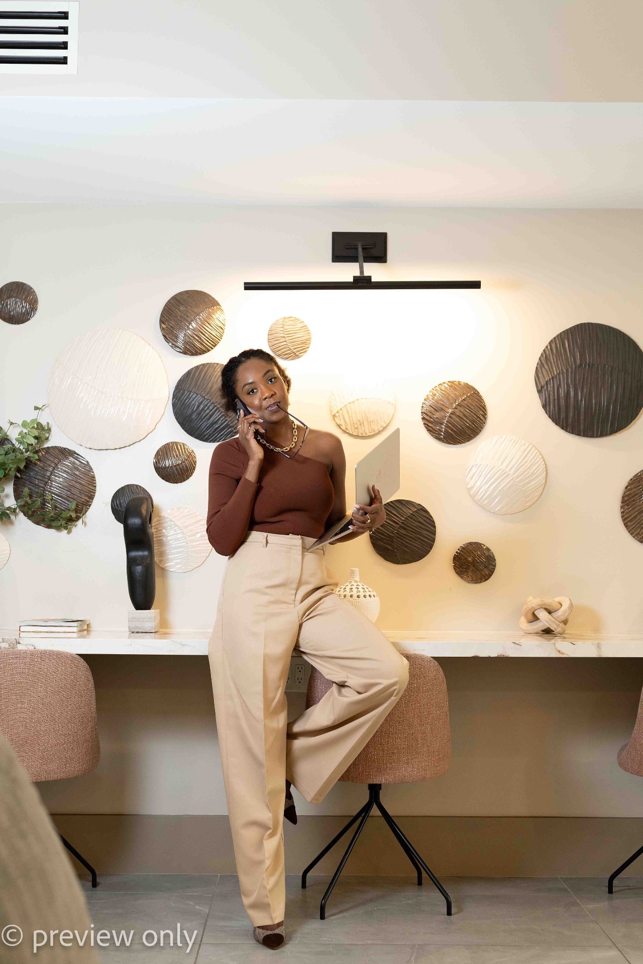 Abimbola Oshodi on a call, laptop in hand