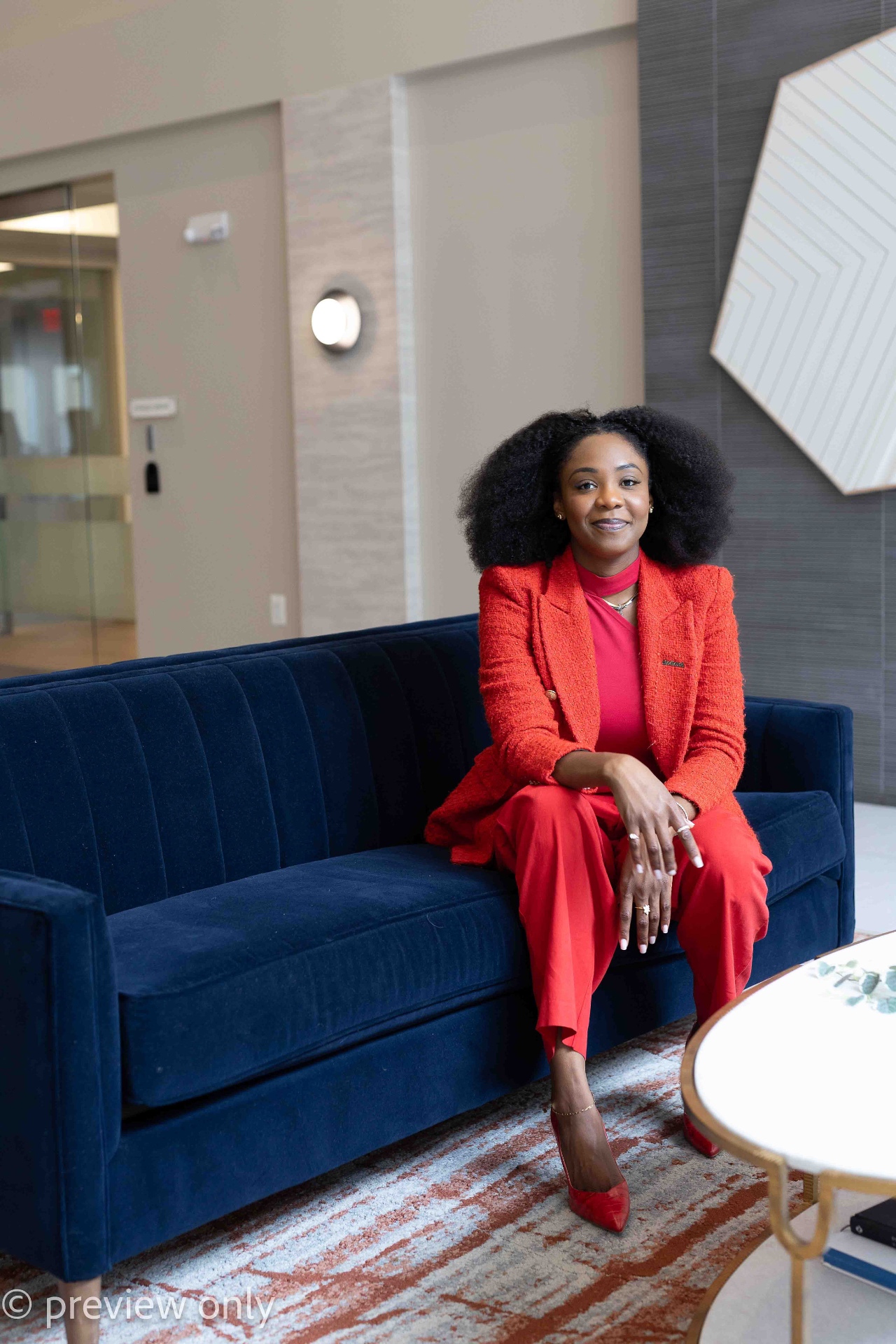 Abimbola Oshodi seated in a red suit